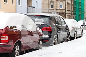 Snowbound cars parked at the roadside