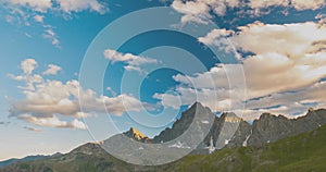 Snowcapped mountain ridges and peaks with moving clouds over the Alps in summer, Torino Province, Italy. Time lapse at sunset.