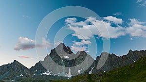 Snowcapped mountain ridges and peaks with moving clouds over the Alps in summer, Torino Province, Italy. Time lapse at sunset. Sli