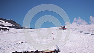 Snowcat caterpillar machine with passangers rides on mountain steep