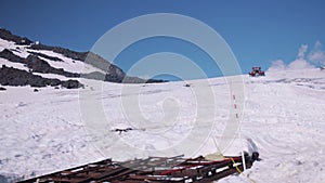 Snowcat caterpillar machine with tourists rides on mountain steep