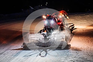 Snowcat ratrack machine making night snow at ski resort