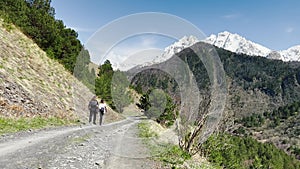 Snowcovered mountains in the background of a dirt road