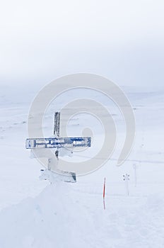 Snowcovered route sign and crossmarks photo