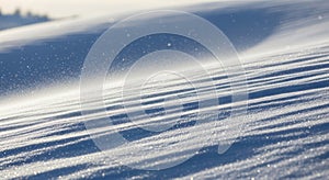 Snowdrift patterns in winter landscape with sunlight and shadows