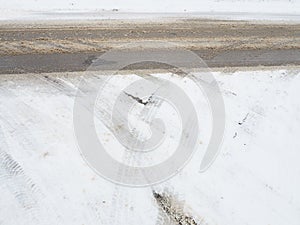 Snowdrifts on the side of the road. Bad weather and traffic. Snow on asphalt. Difficult driving conditions. Winter slosh