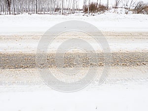 Snowdrifts on the side of the road. Bad weather and traffic. Snow on asphalt. Difficult driving conditions. Winter slosh