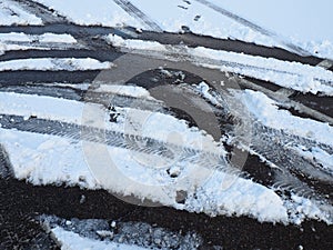 Snowdrifts on the side of the road. Bad weather and traffic. Snow on asphalt. Difficult driving conditions. Winter slosh