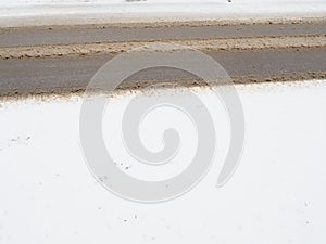 Snowdrifts on the side of the road. Bad weather and traffic. Snow on asphalt. Difficult driving conditions. Winter slosh