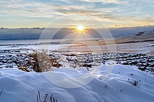 Snowed in hill overlooking frosted houses and lake in Draper Utah in winter