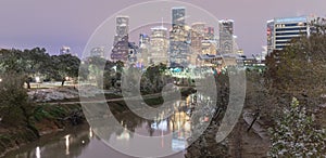 Snowfall along Bayou River bank and downtown Houston