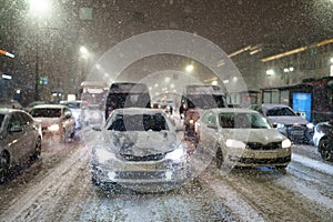 Snowfall and traffic collapse city. Cars standing in jam on road due to snow storm, bad visibility