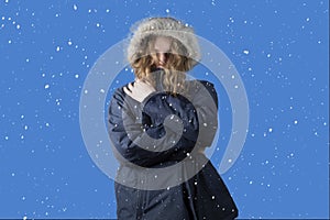 Snowfall. Winter. A person freezes in cold weather.A man in a winter jacket is standing on the street