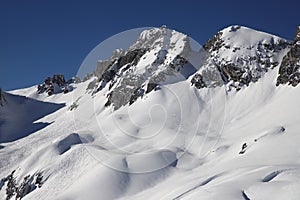 Snowfield and snow covered high alpine mountain peaks