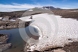 Snowfields on stone placers near a volcano photo