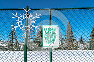 Snowflake decor and Resident Parking sign on green mesh wire fence in Park City