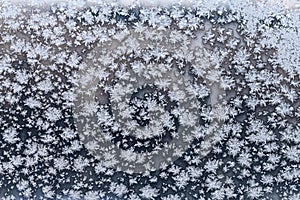 Snowflake and frost on frozen windowpane in winter