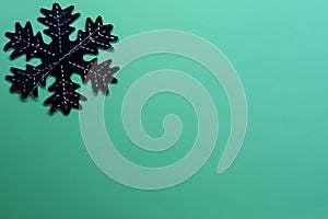 Snowflake on a green background. Festive background. Holiday concept. Christmas and New Year concept. Top view, flat lay