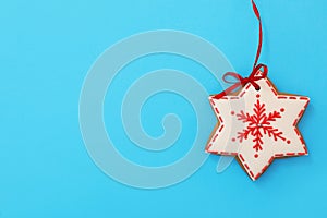 Snowflake shaped Christmas cookie on light blue background, top view. Space for text