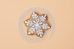 Snowflake shaped gingerbread cookie on color background, top view. Close-up. Homemade Christmas cookies. Happy new year and merry