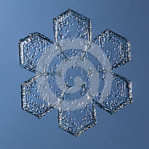 Snowflake on smooth gradient background. Macro photo of real snow crystal on glass surface. This is small snowflake with
