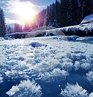 Snowflakes as a snow butterflies over frozen icy river. Frosty nature background