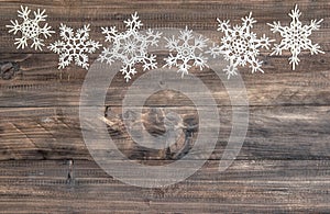 Snowflakes border over wooden background. christmas decoration