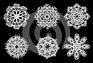 Snowflakes cut out of paper on a black background