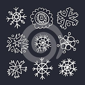 Snowflakes drawn in childish style linear icons set on black