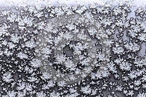 Snowflakes and frost on frozen window pane