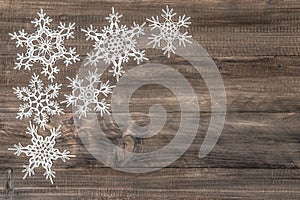 Snowflakes over rustic wooden background