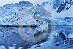 Snowing Floating Blue Iceberg Arch Reflection Paradise Bay Skintorp Cove Antarctica