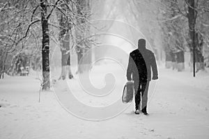 Snowing landscape in the park with people passing by