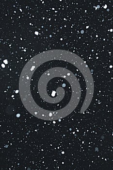 Snowing with snowflakes on black background photo