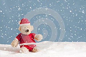 Snowing on teddy bear in christmas clothes photo