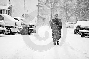 Snowing urban landscape with people passing by