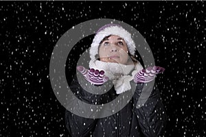 Snowing on young woman in wiinterclothes