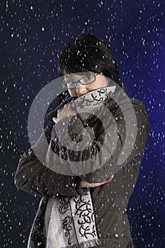 Snowing on young woman with wintercoat and shawl