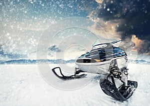 Snowmachine on the mountain lake frozen surface with thunderstorm clouds on the background