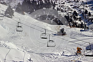 snowmaking cannon sprays snow on the ski slope