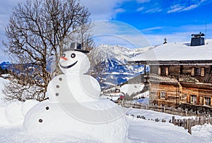 Snowman on the background of a snowy mountain. Ski resort Soll