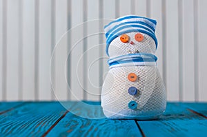 Snowman on blue wooden background. With empty