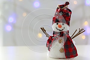 Snowman with bokeh christmas lights in the background