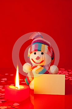 Snowman with burning heart shaped candle