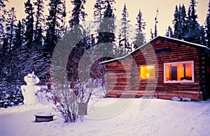 Snowman cozy illuminated log cabin winter vacation