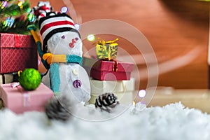 Snowman for decorating with Christmas tree with colorful gift boxes on snow ground for Christmas holiday celebration