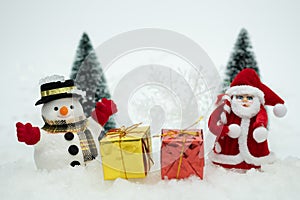 Snowman with gift box is standing in snowfall, Merry Christmas and happy New Year concept