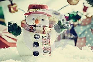 Snowman and light bulb stand among pile of snow at silent night, light up the hopefulness and happiness in Merry christmas and hap