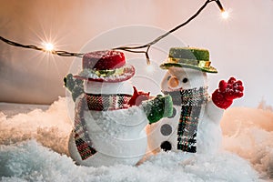 Snowman and light bulb stand among pile of snow at silent night, Merry christmas and Happy new year night.
