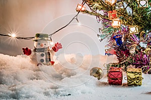 Snowman and light bulb stand among pile of snow at silent night, Merry christmas and Happy new year night.